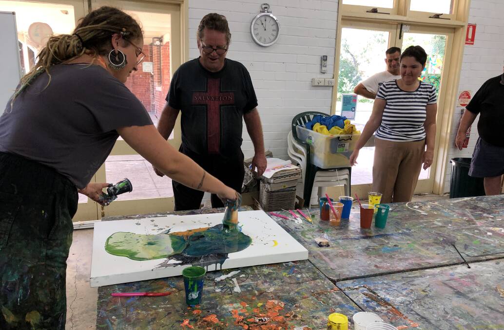 Arts North West project officer Julia Minors helps Bruce Cantrill, Sarah Briggs and David Briggs with some art therapy at BAMM.